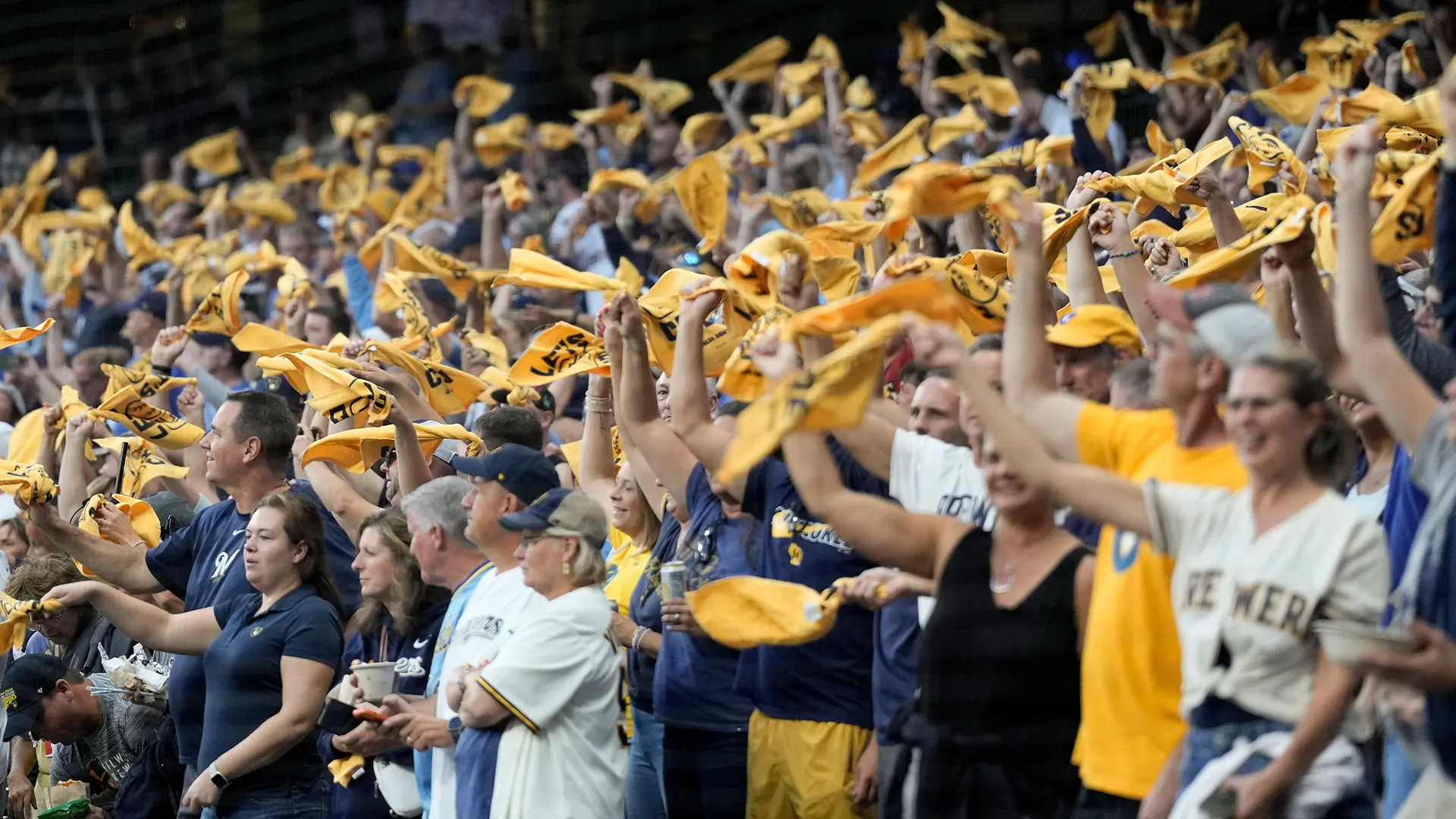 A crowd of baseball fans is pictured waving yellow towels.