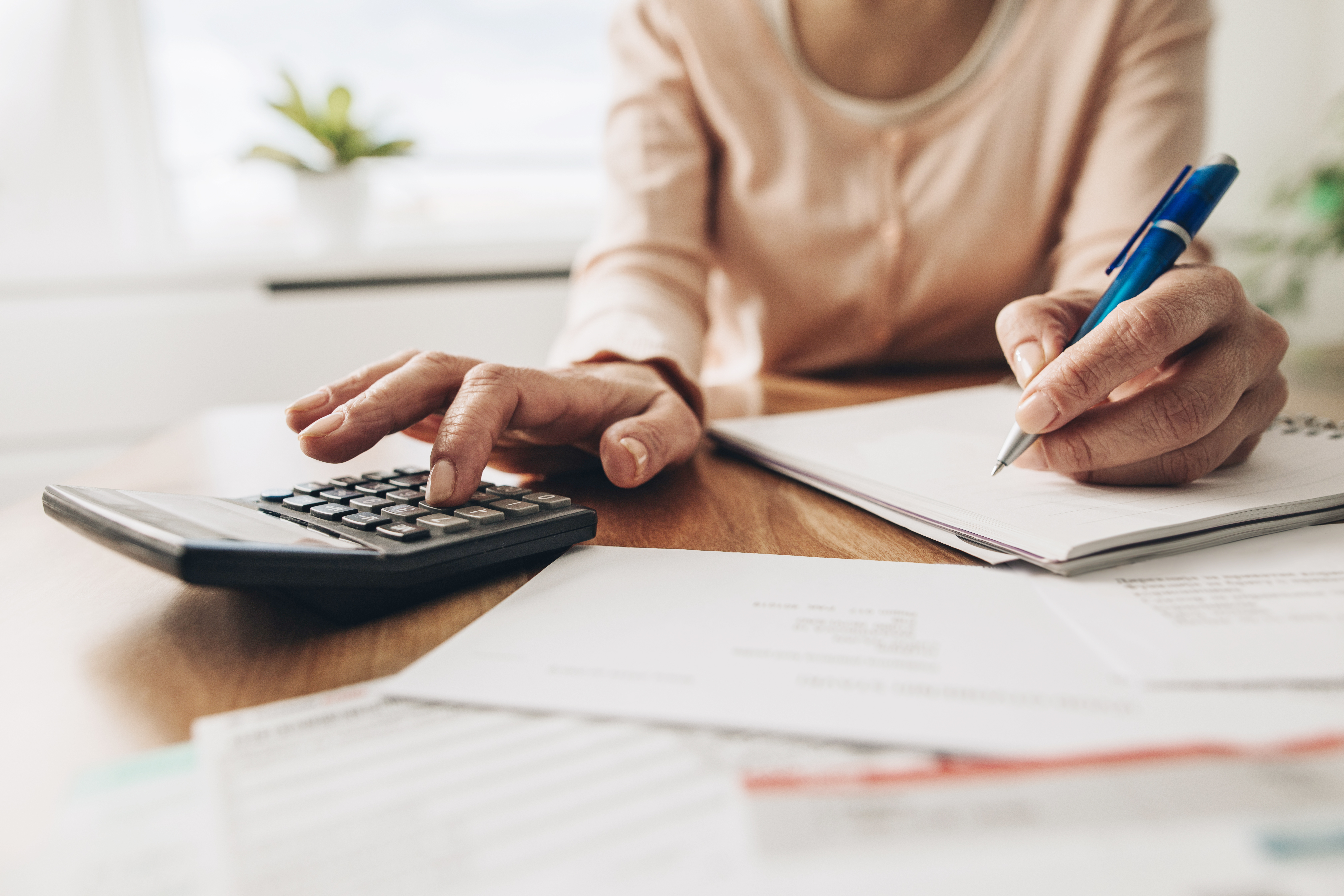 A woman calculates her home equity on a calculator.