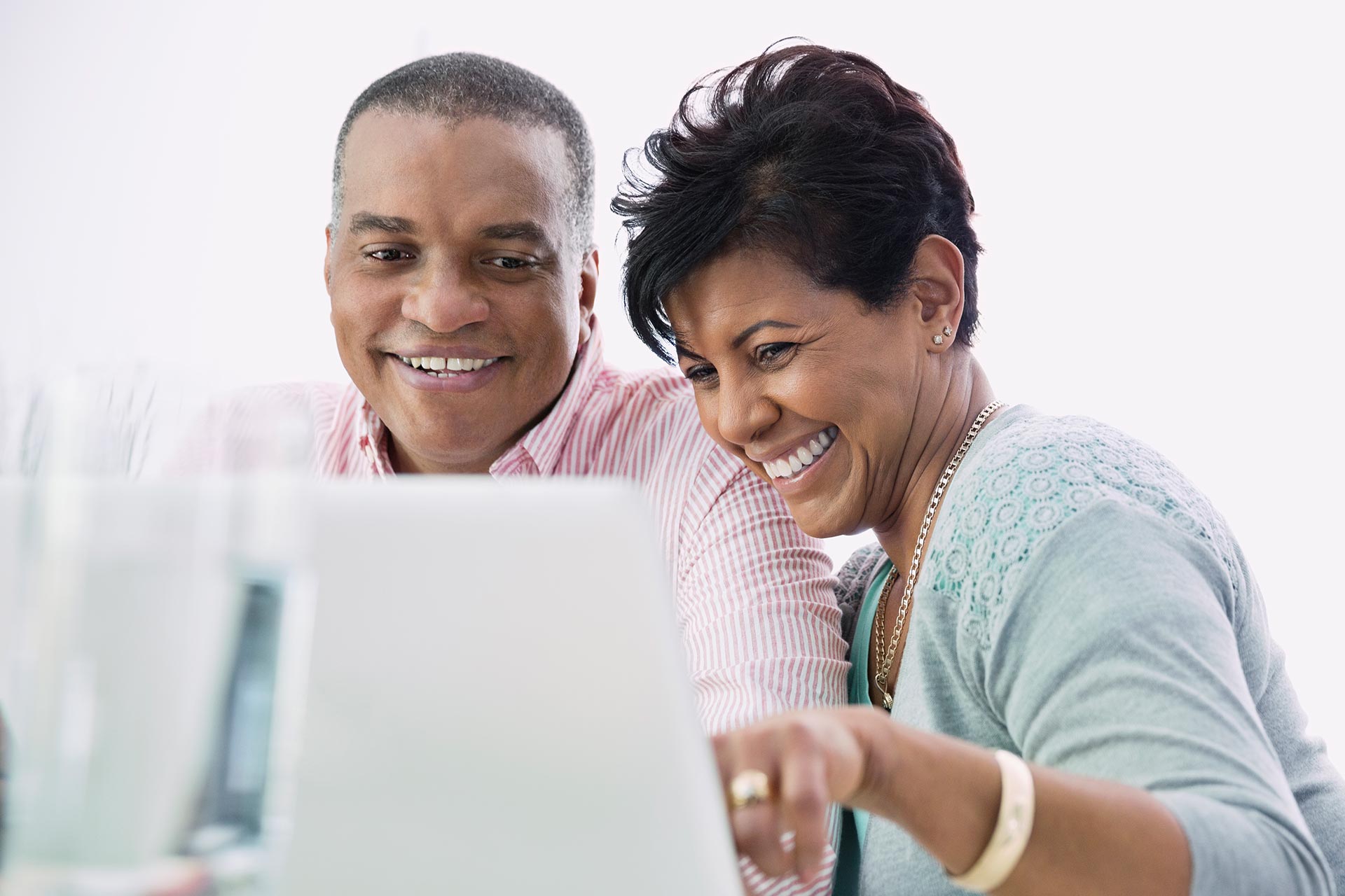 Man and woman smile while looking at a computer screen