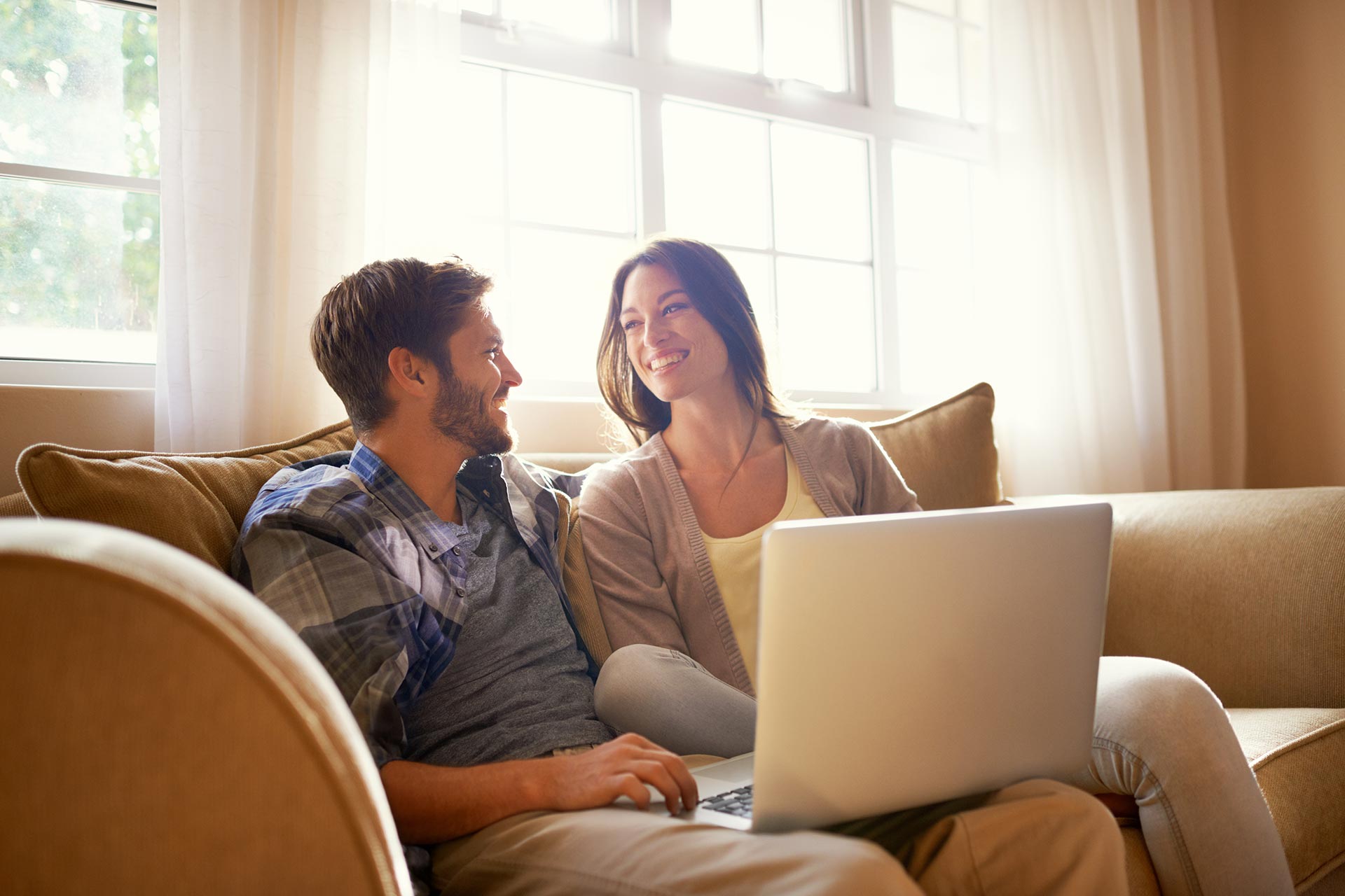 Couple sits together on the couch to discuss financial planning