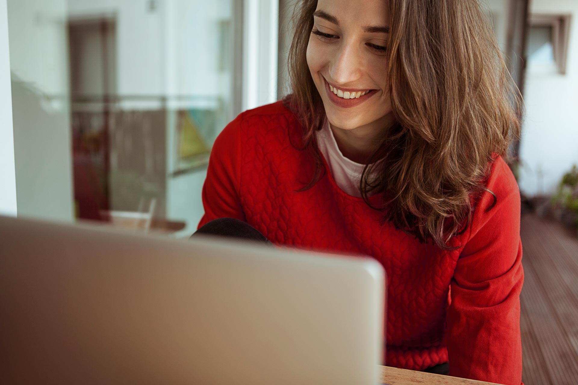 Woman smiling looking at her laptop. 