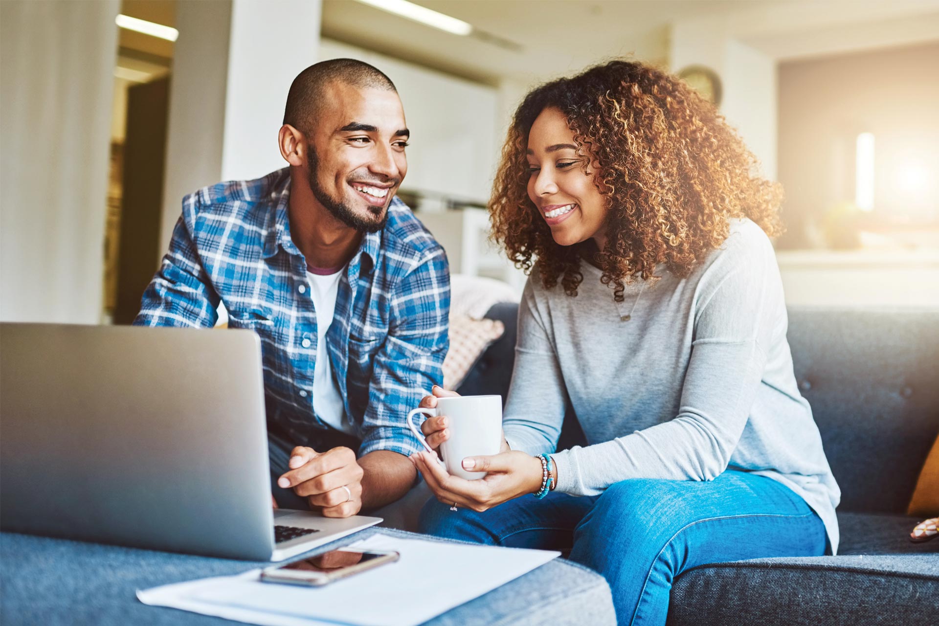 Young couple reviewing the benefits of consolidating debt with a personal loan via their laptop.