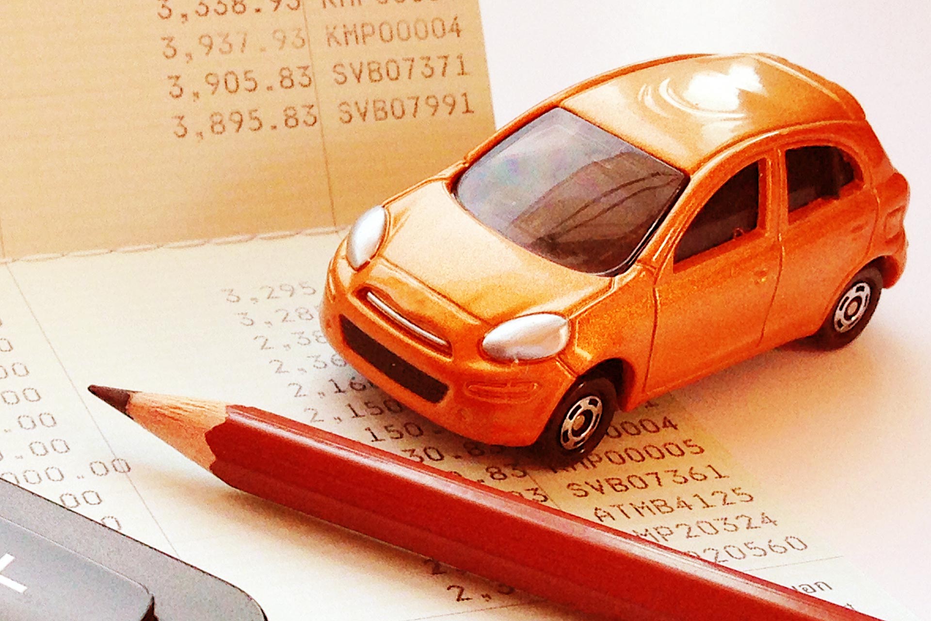 Car sitting on desk by expenses.