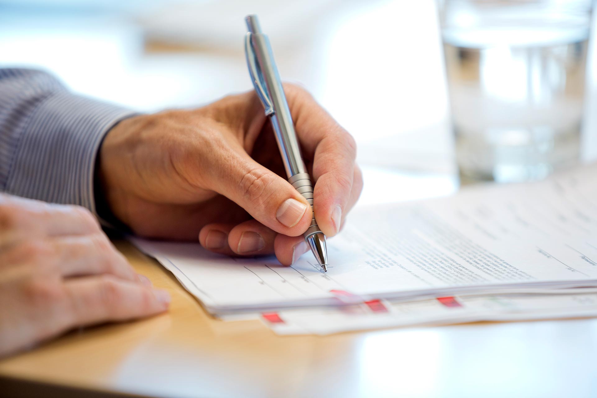 Man signing closing documents on purchased home.