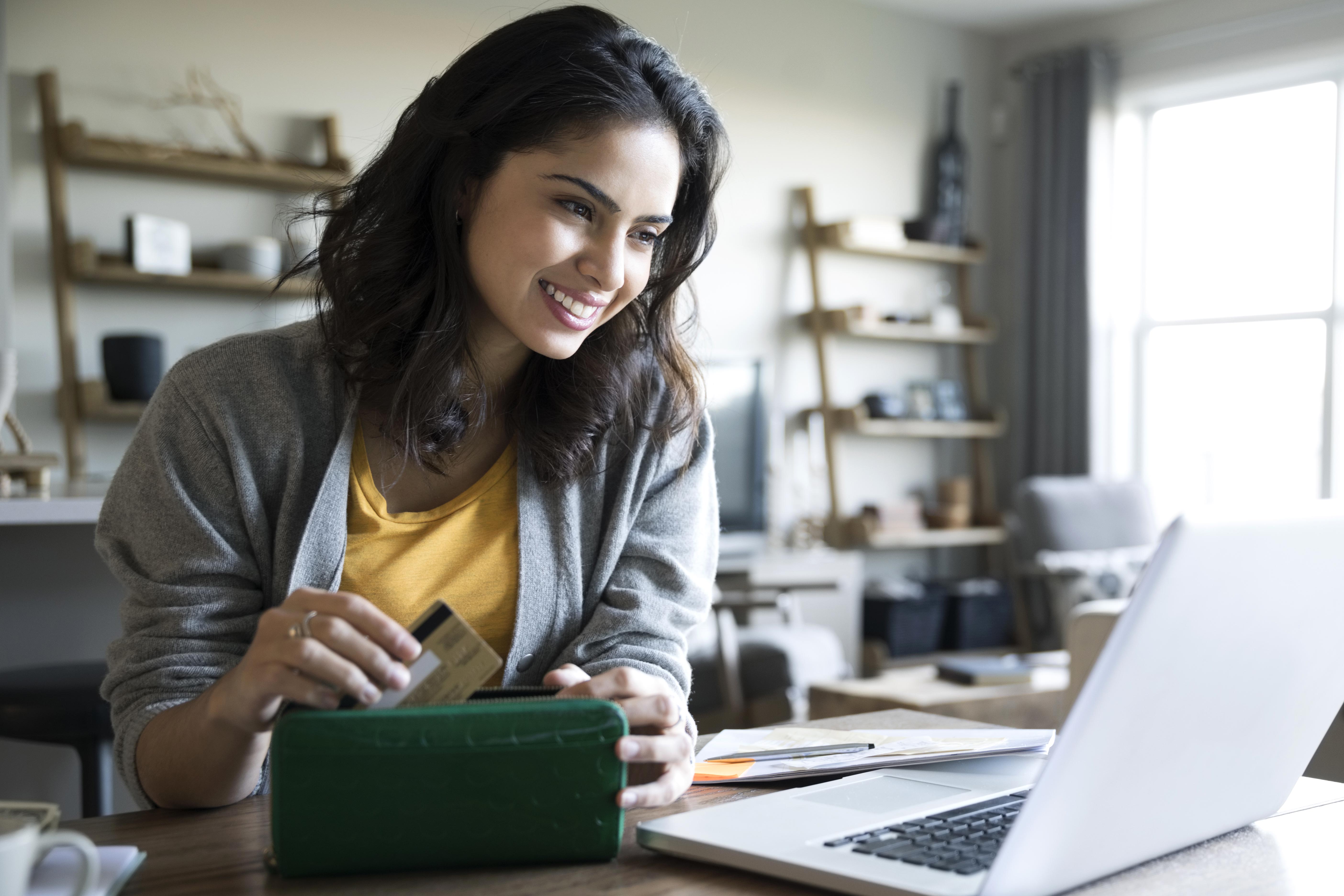 Woman uses credit card on a laptop.