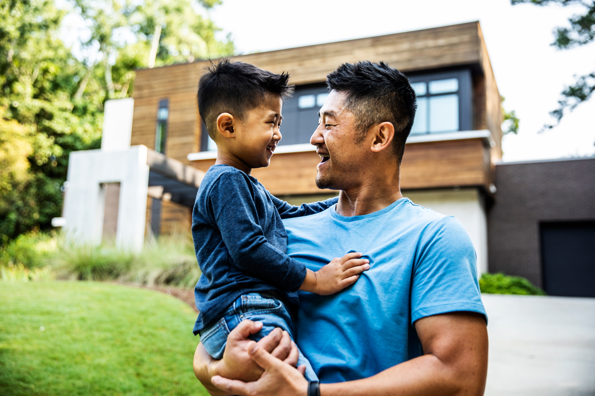 A father and son stand in the driveway of a new home purchased with a UWCU home loan.