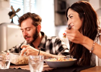 Couple eating dinner in their new home together.