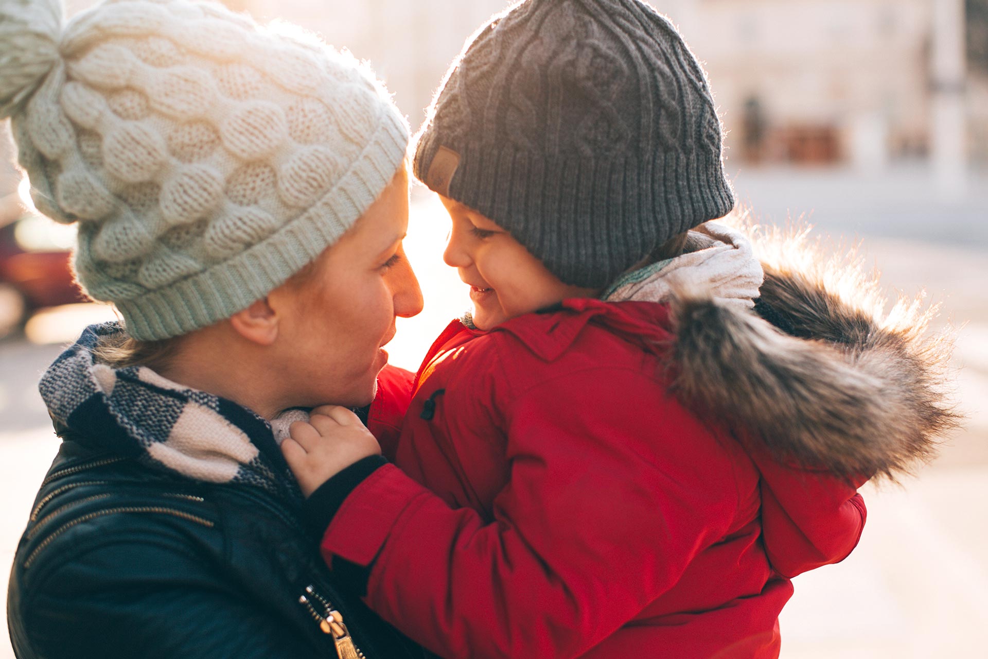 Woman holds a child outside in the winter