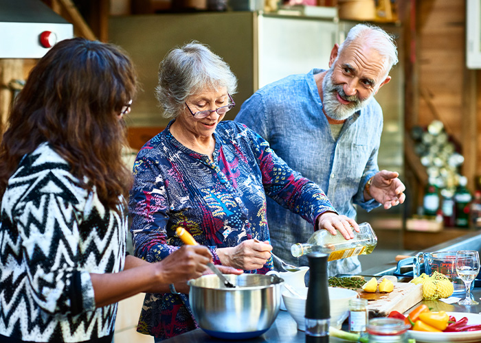 A group of seniors are cooking together after learning retirement saving strategies