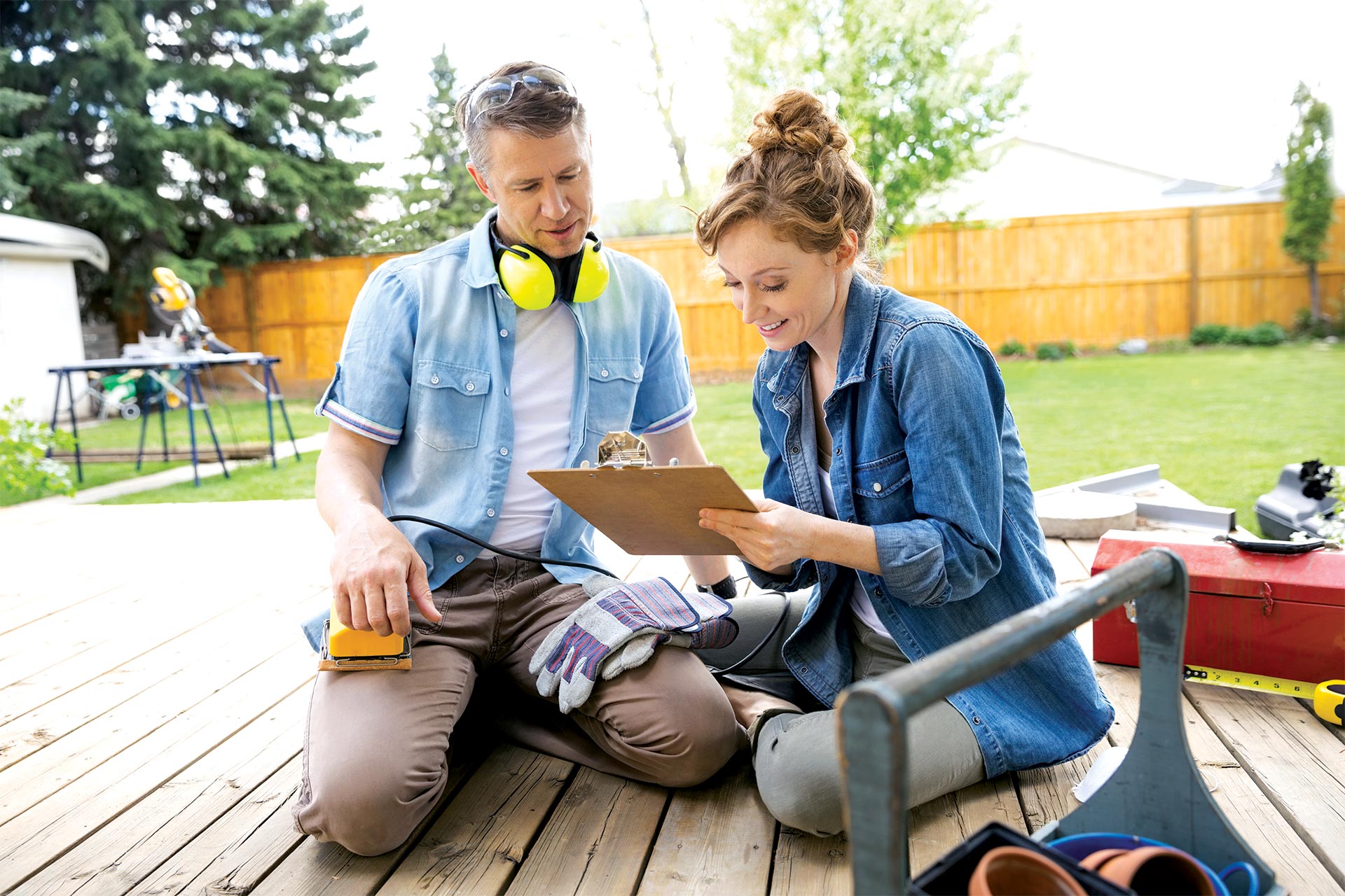 Man and woman doing home improvement projects on their deck. 