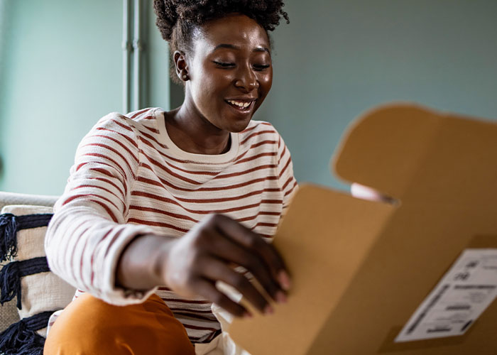 A UW Credit union member opens a packaged ordered safely online thanks to these six tips