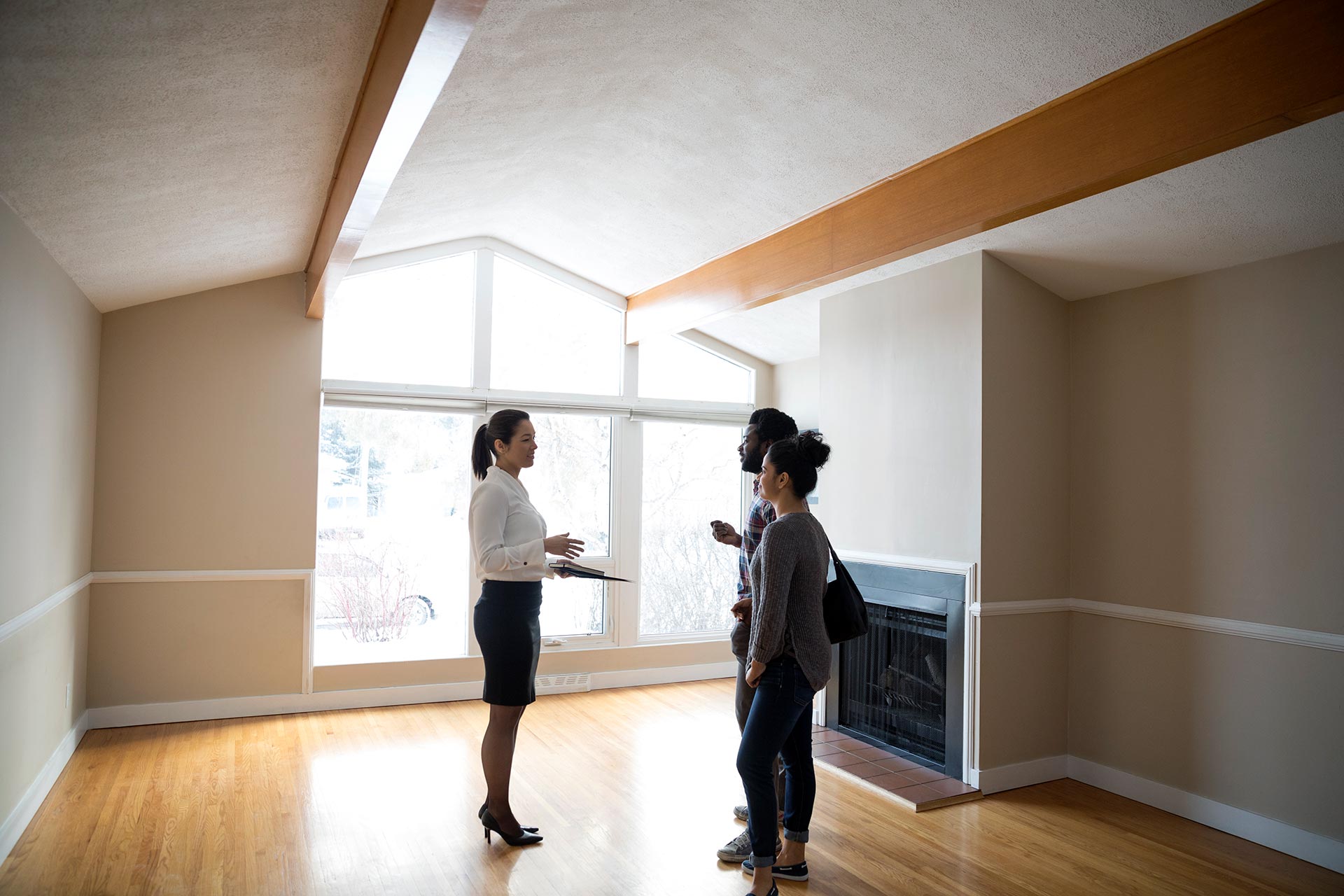 Couple walks through a home with a realtor.