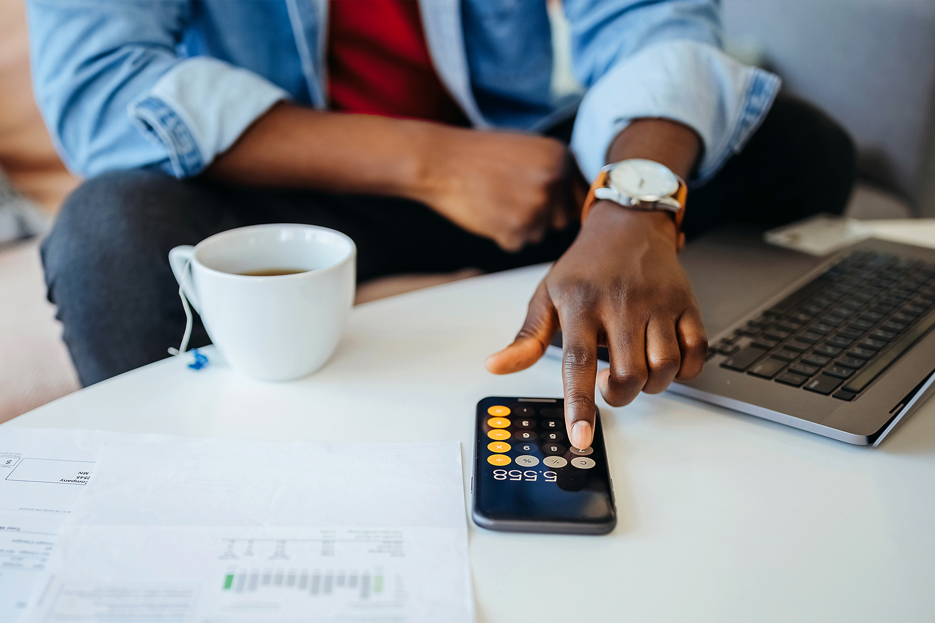 A man using his calculator to understand how inflation will impact his budget.