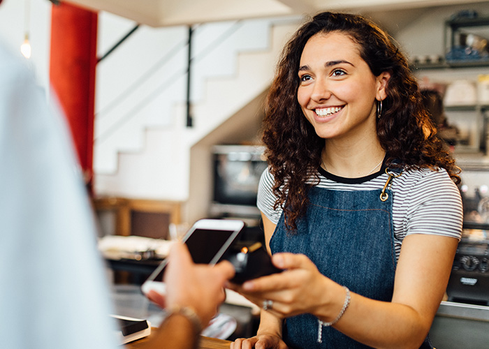 A smiling employee at her summer job working to save and invest