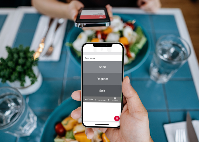 Person making a payment to their friend on their phone
