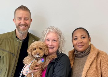 UW Credit Union Member Ginger Alberts Coral, Mortgage Loan Officer Cory Poole, and nonprofit founder Tiffany Malone are pictured together. Ginger is holding her mini-poodle, Mazy. 