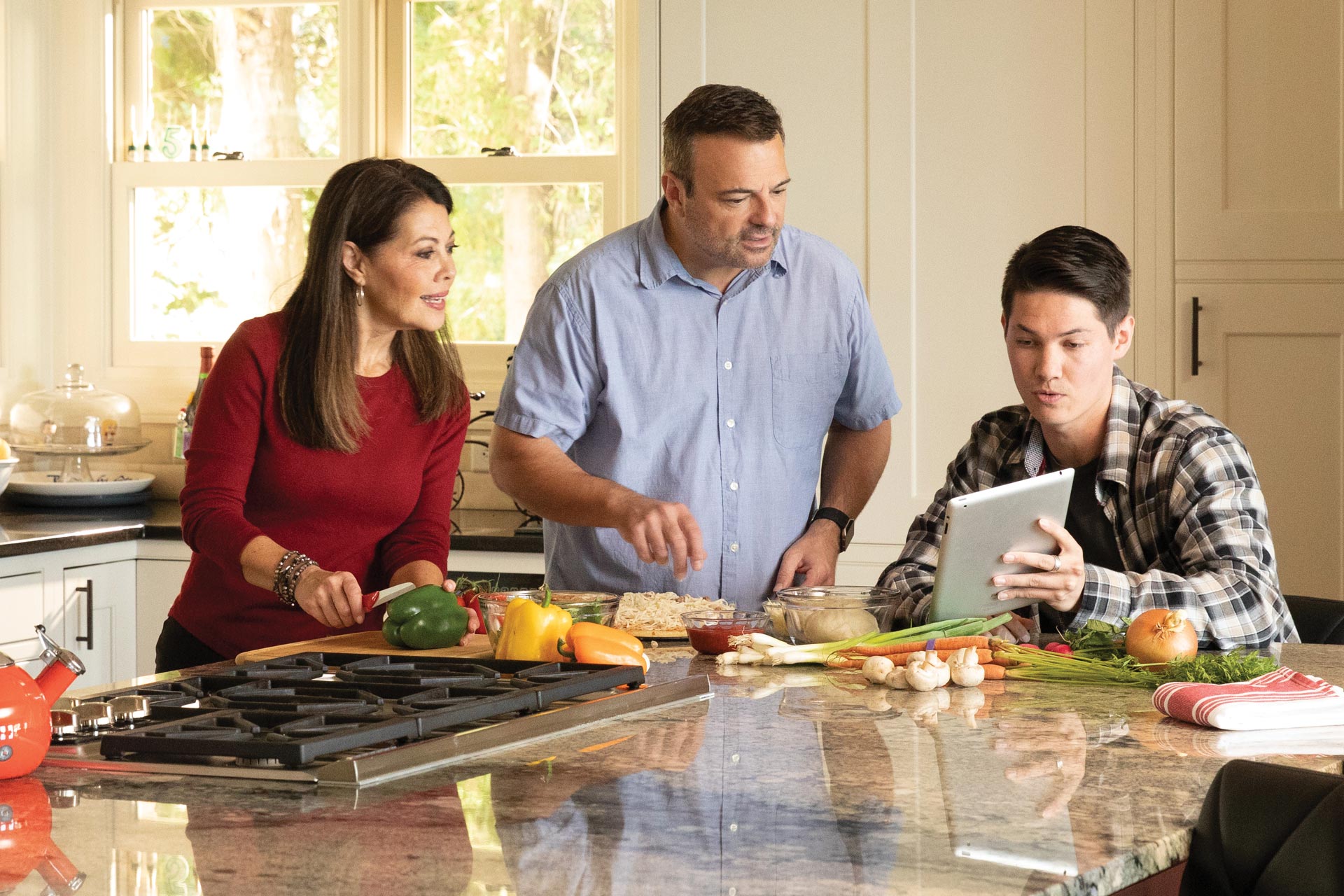 Parents with son looking online at Private Student Loan options available at UWCU.