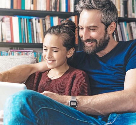 Father looks at IRA specials with his daughter on a tablet.